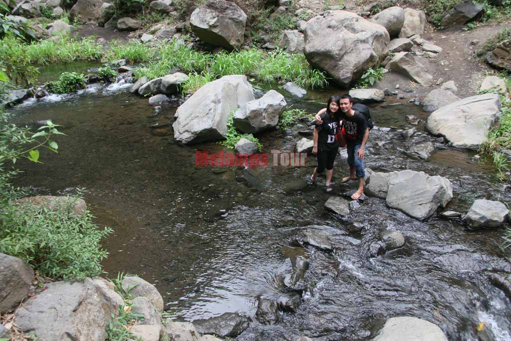 A couple traveller at the river stream - Madakaripura waterfall